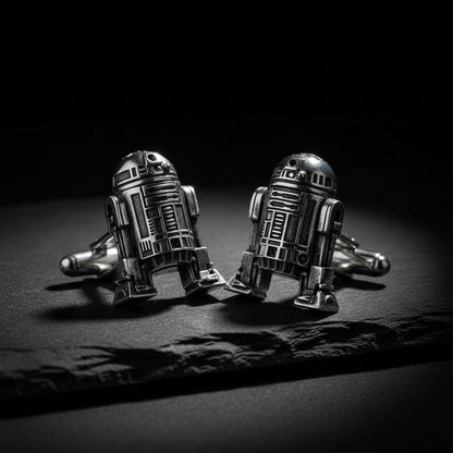 Silver R2-D2 cufflinks on a black flint stone. 
