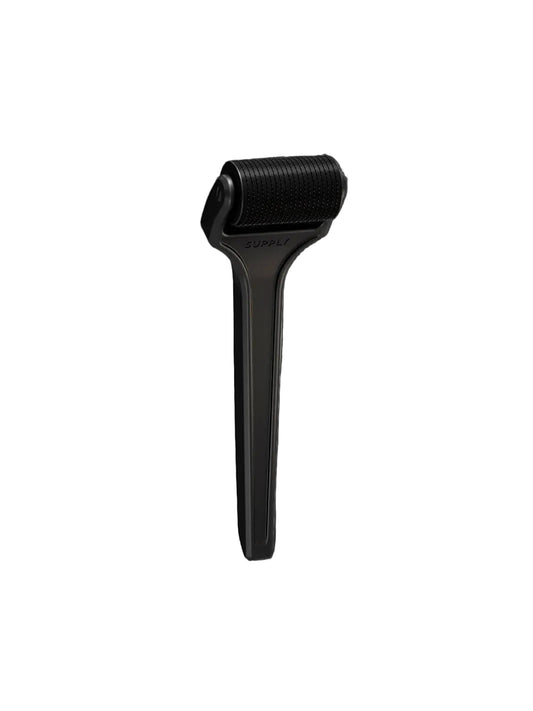 Black skin care tool on a white background