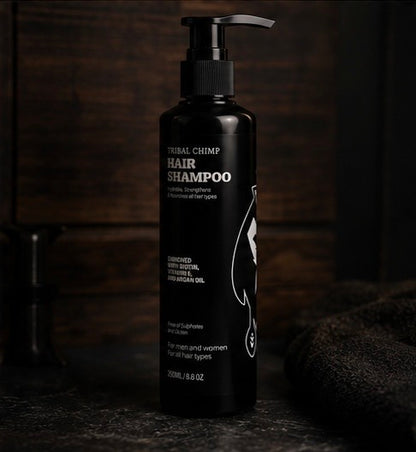 Black bottle of Tribal Chimp hair shampoo on a dark background