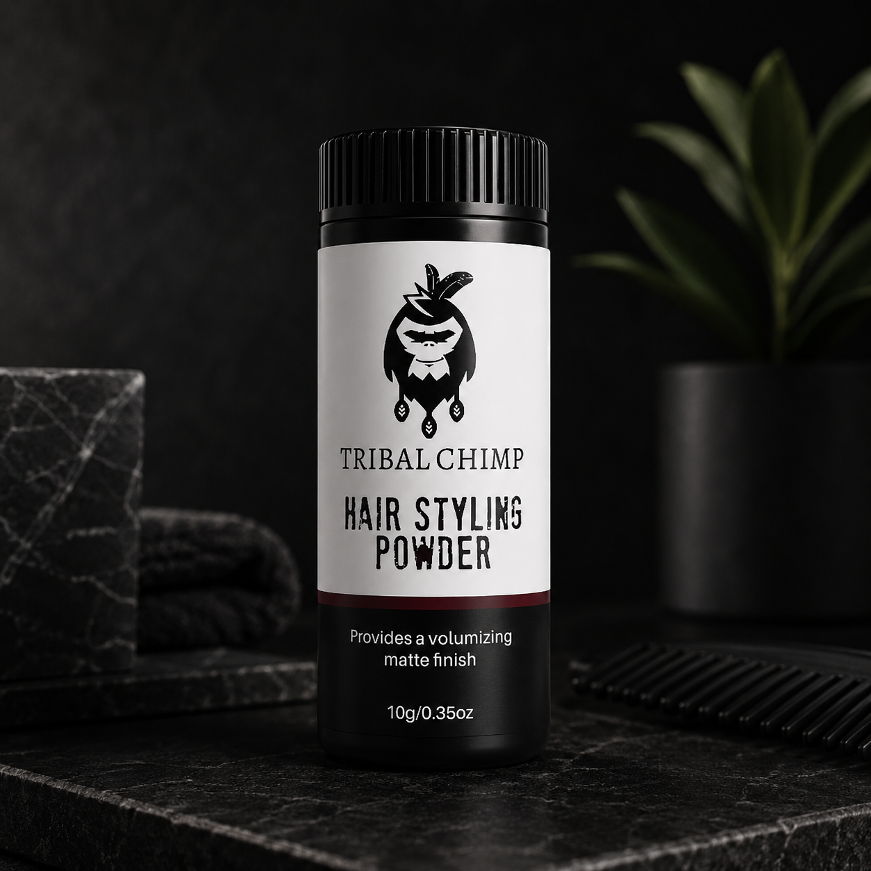 Tribal Chimp hair styling powder bottle on a dark surface with a blurred background